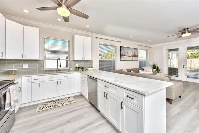 a kitchen with granite countertop a sink cabinets stainless steel appliances and a window