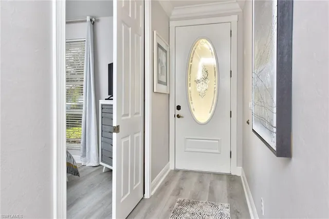 a view of a hallway with wooden door door and windows