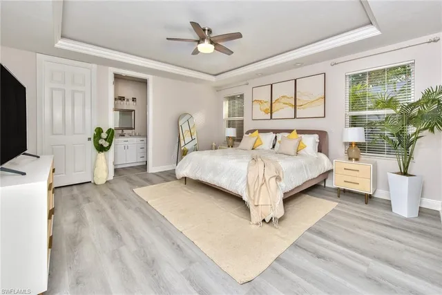 a bedroom with a bed couches and a flat tv screen