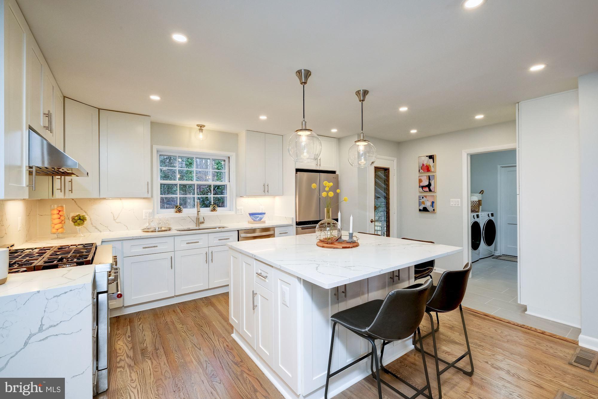 7440 Arrowood Road Bethesda, MD 20817 - Photo 21 of 79 a kitchen with a dining table chairs stove refrigerator and cabinets