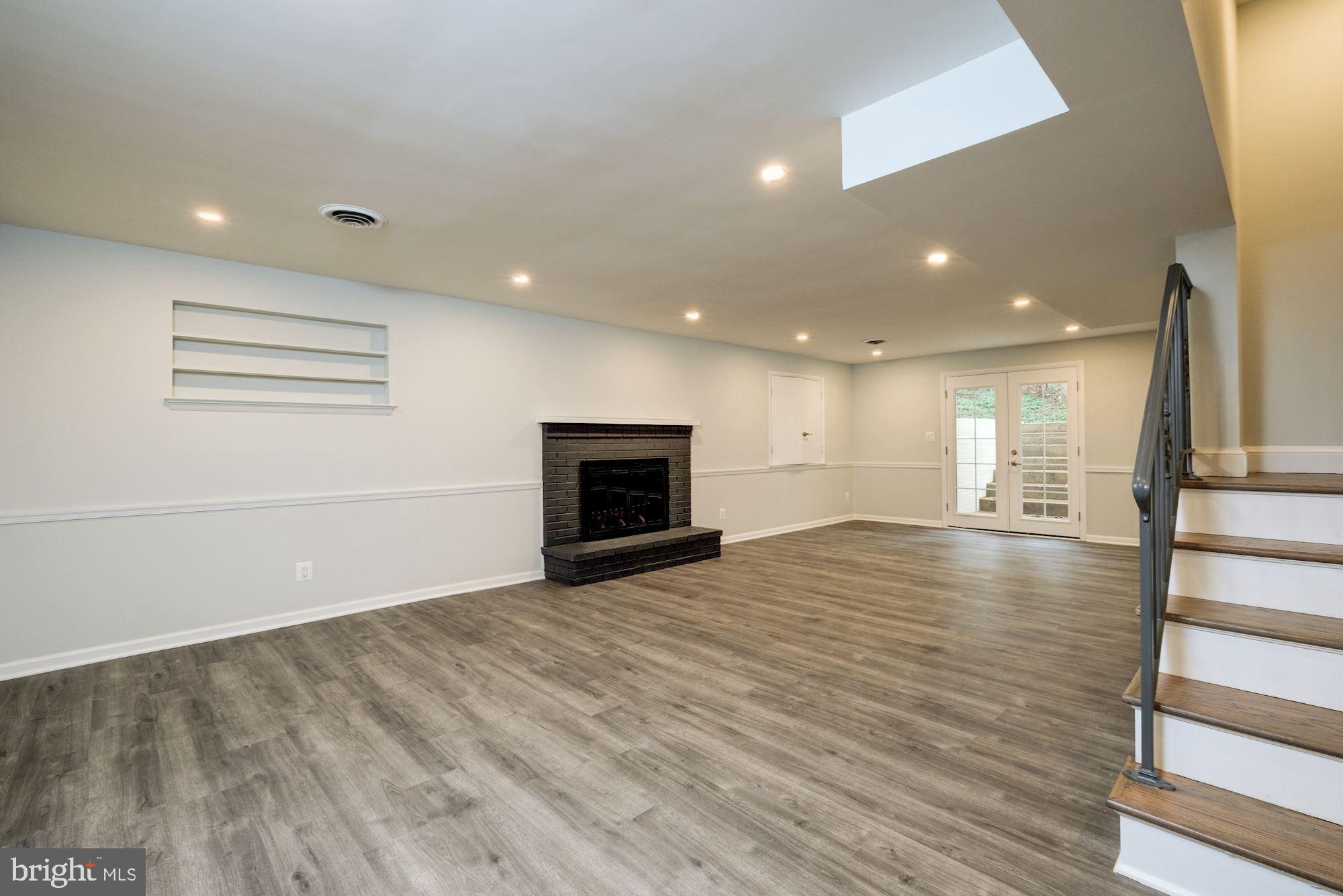 7440 Arrowood Road Bethesda, MD 20817 - Photo 63 of 79 a view of empty room with wooden floor and fireplace