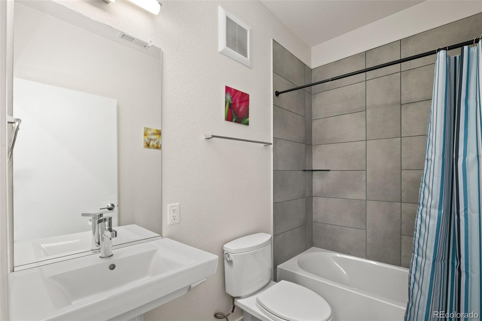 1204 South Reed Street Lakewood, CO 80232 - Photo 20 of 45 a bathroom with a toilet sink and shower