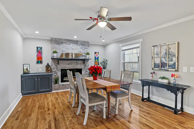 a dining room with furniture a fireplace and wooden floor