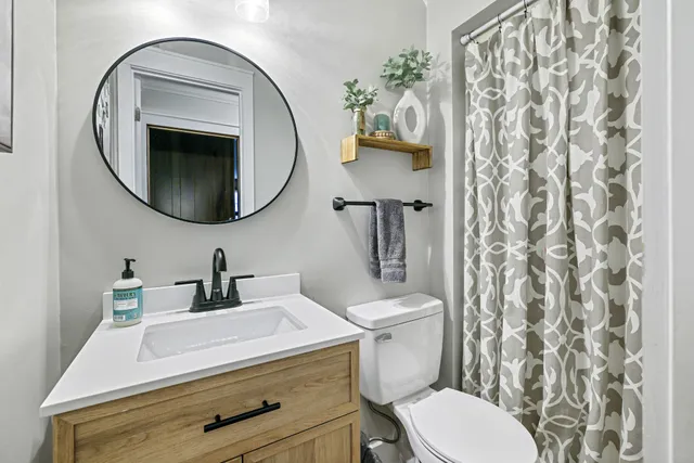 a bathroom with a sink a toilet and a mirror