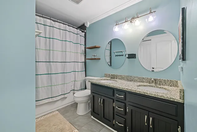 a bathroom with a double vanity sink mirror and toilet