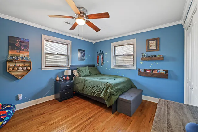 a bedroom with a bed and a dresser next to a window