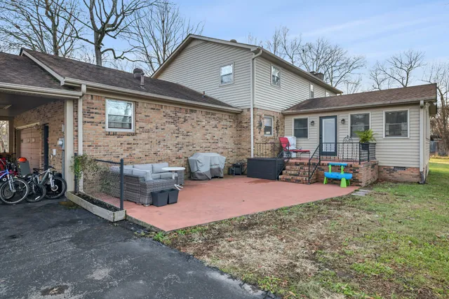 a view of a house with a patio and a yard