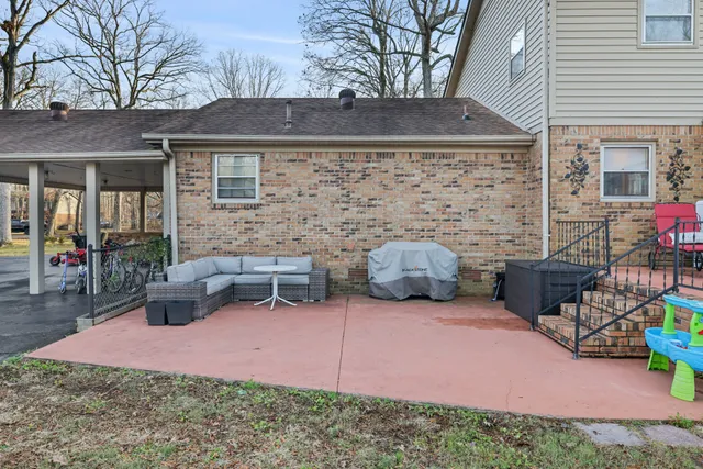 a view of a backyard with table and chairs potted plants and a house