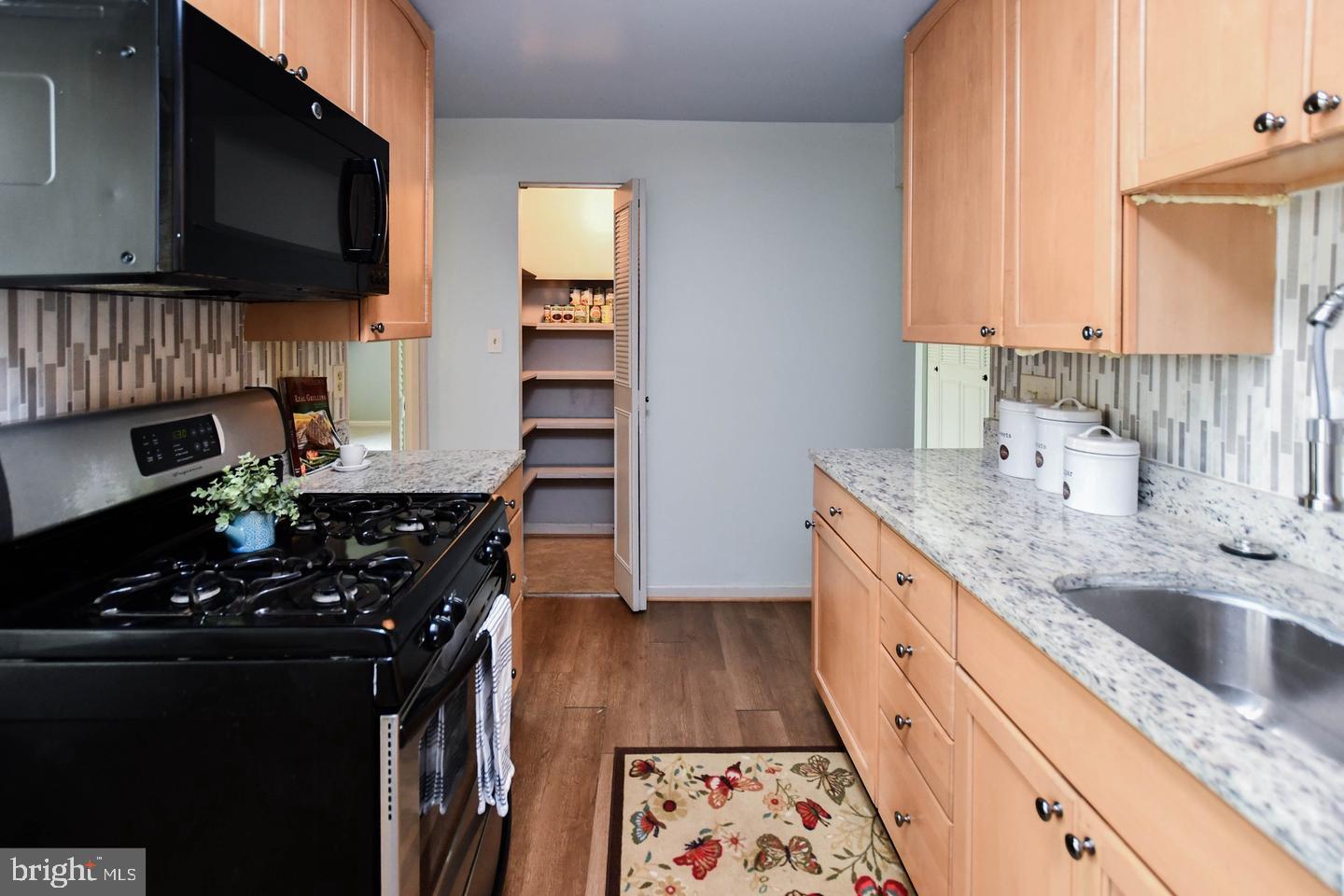 3319 Huntley Square Drive, Unit A Temple Hills, MD 20748 - Photo 7 of 17 a kitchen with granite countertop a sink stove and cabinets
