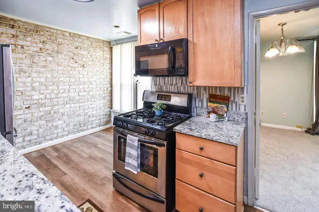 a kitchen with stainless steel appliances granite countertop a stove and a microwave