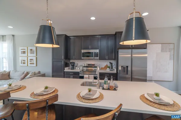 a kitchen with stainless steel appliances kitchen island granite countertop a table and chairs