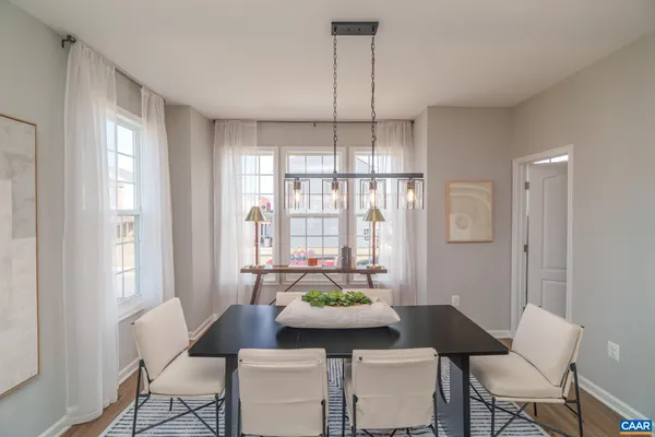 a dining room with furniture a chandelier and wooden floor