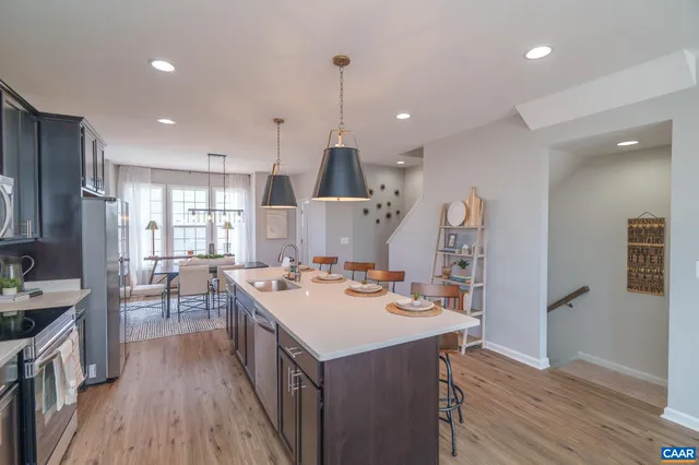a kitchen with a sink stove and wooden floor