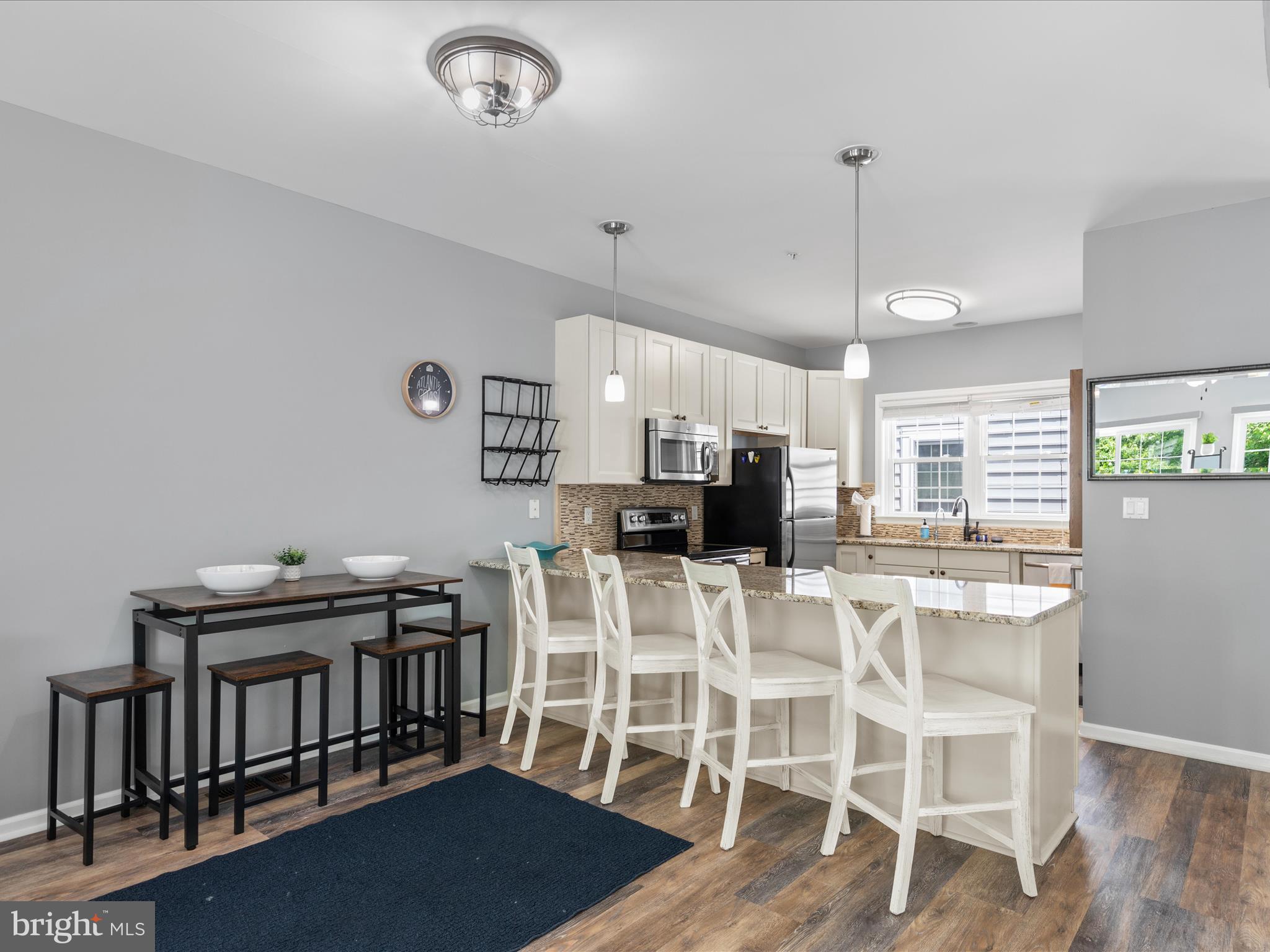 9739 Golf Course Road, Unit D102 Ocean City, MD 21842 - Photo 19 of 78 a view of a dining room with furniture a chandelier and wooden floor