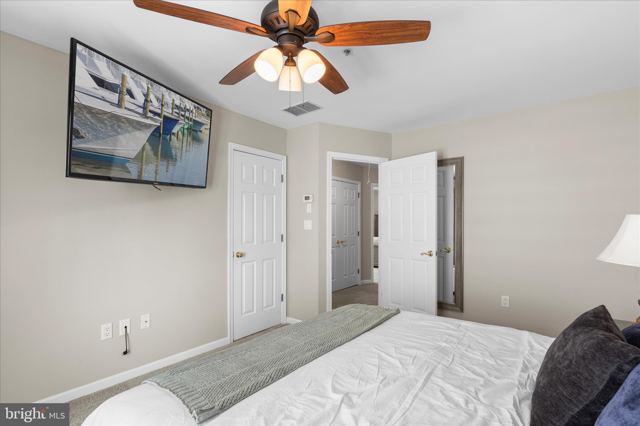 9739 Golf Course Road, Unit D102 Ocean City, MD 21842 - Photo 26 of 78 a bedroom with a bed and a chandelier