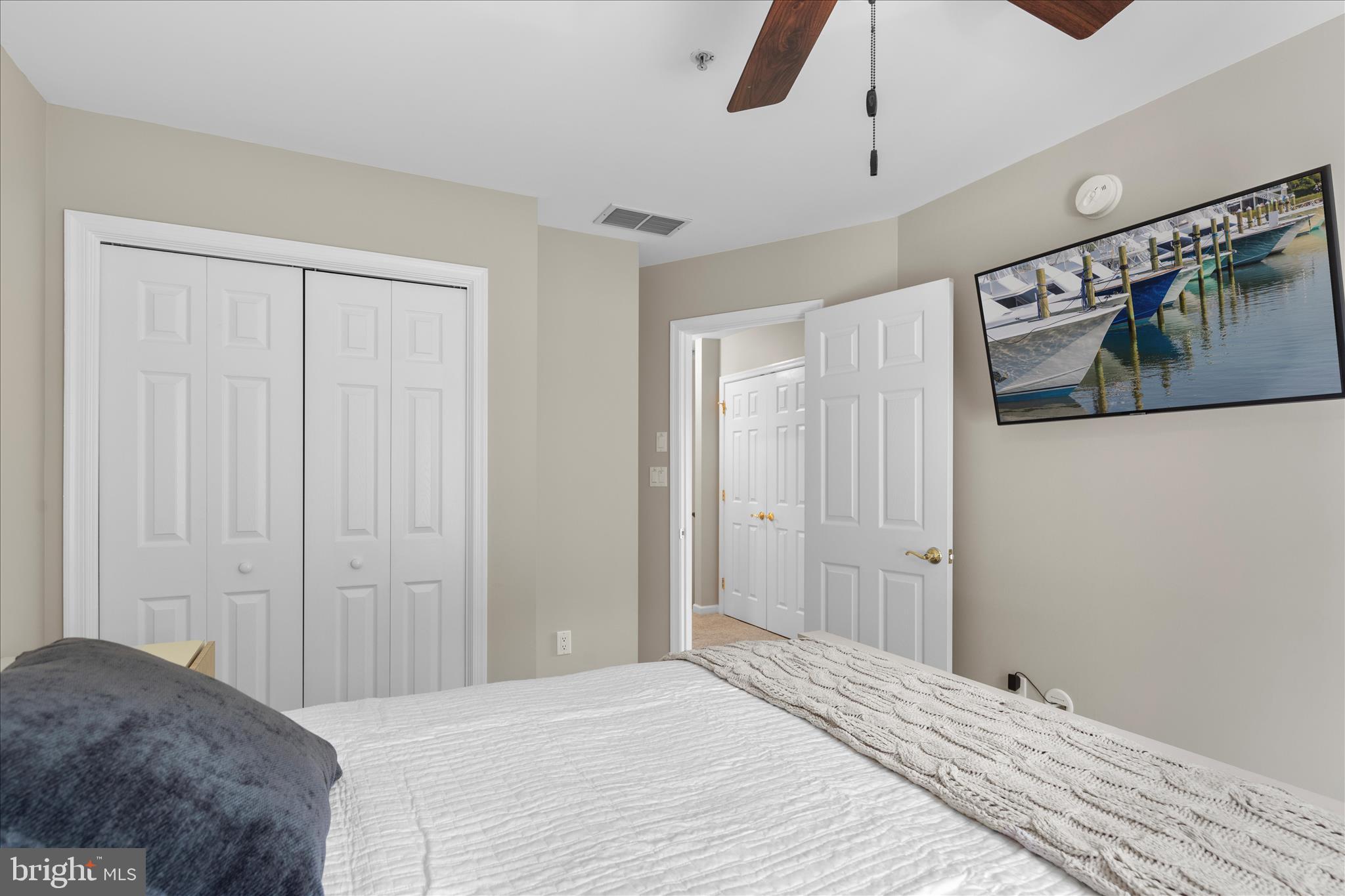 9739 Golf Course Road, Unit D102 Ocean City, MD 21842 - Photo 46 of 78 a bedroom with a bed and a chandelier
