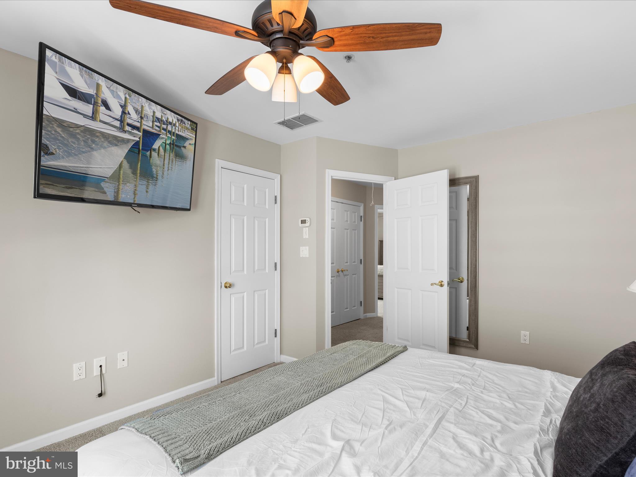 9739 Golf Course Road, Unit D102 Ocean City, MD 21842 - Photo 49 of 78 a bedroom with a bed and a chandelier
