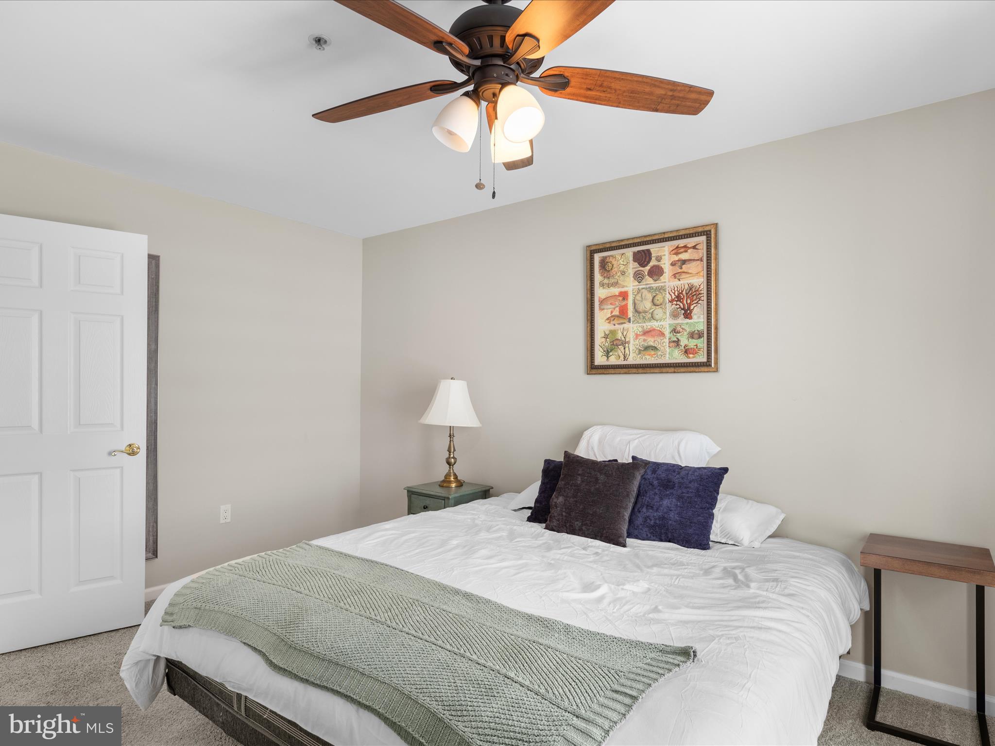 9739 Golf Course Road, Unit D102 Ocean City, MD 21842 - Photo 51 of 78 a bedroom with a bed and a chandelier