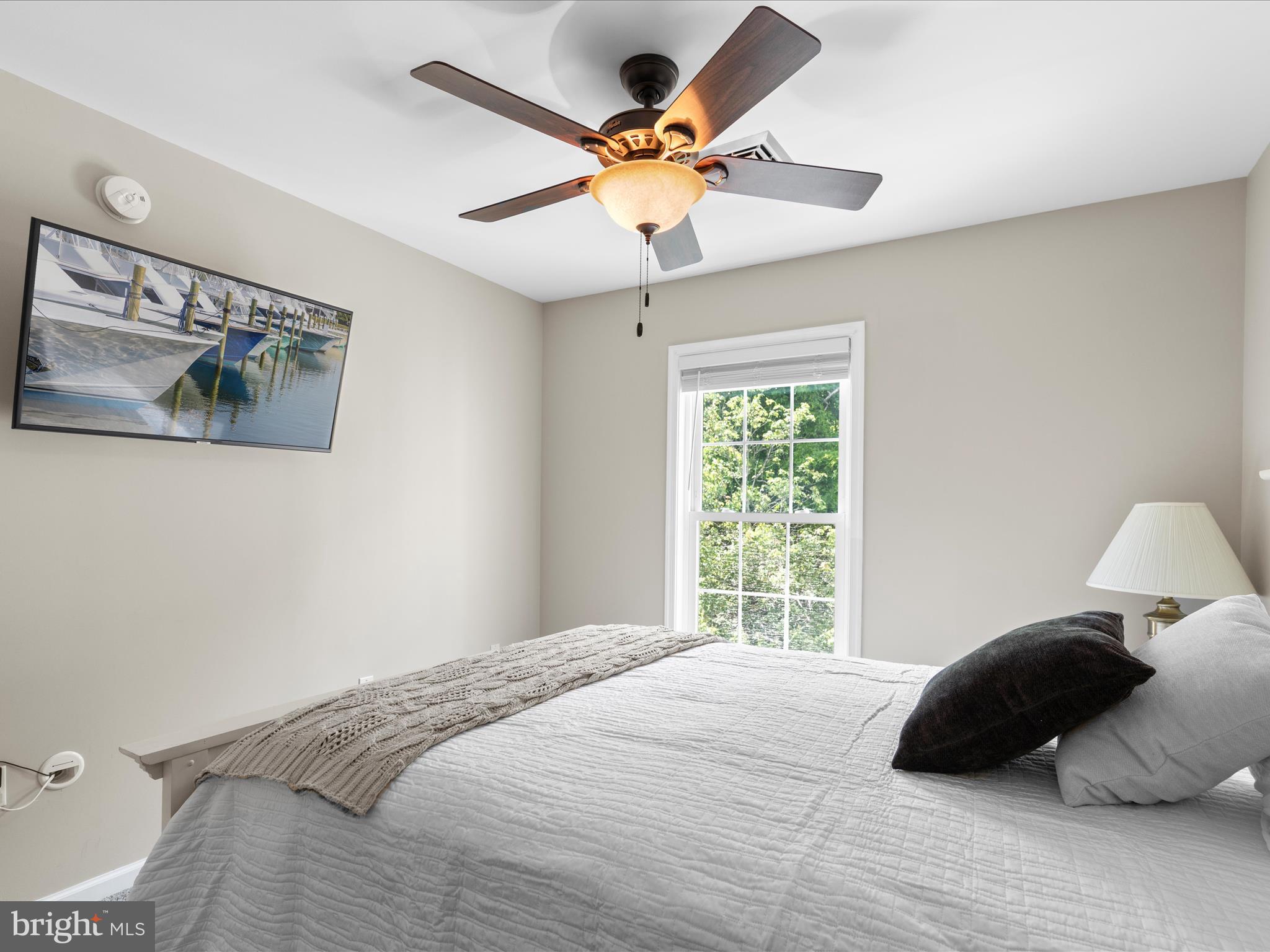 9739 Golf Course Road, Unit D102 Ocean City, MD 21842 - Photo 70 of 78 a bedroom with a bed window and a ceiling fan
