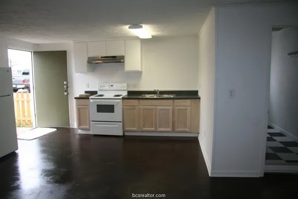 a kitchen with granite countertop a stove and a refrigerator