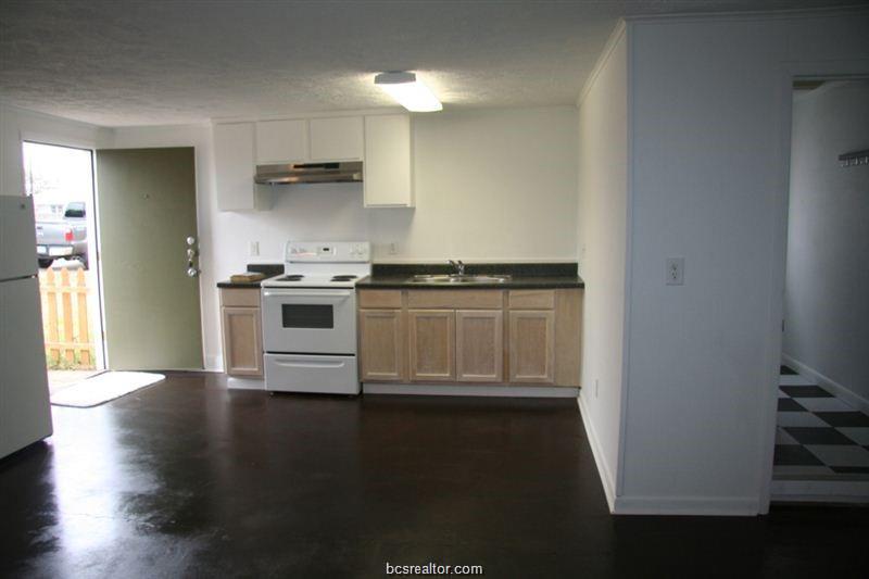 3109 Maloney Avenue, Unit A Bryan, TX 77801 - Photo 2 of 13 a kitchen with granite countertop a stove and a refrigerator
