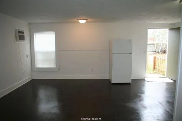 a view of a room with wooden floor and a window