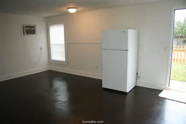 an empty room with wooden floor and a window
