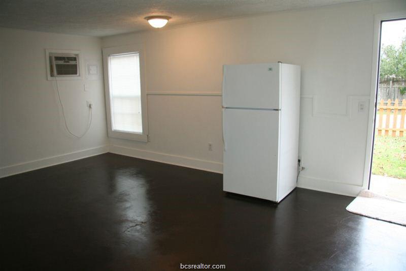 3109 Maloney Avenue, Unit A Bryan, TX 77801 - Photo 6 of 13 an empty room with wooden floor and a window