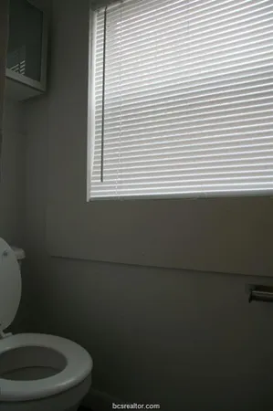 a bathroom with a toilet a sink and a window