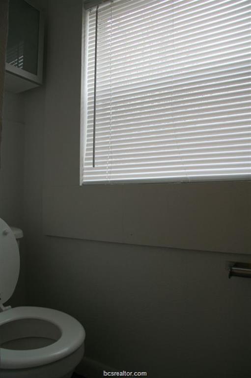 3109 Maloney Avenue, Unit A Bryan, TX 77801 - Photo 8 of 13 a bathroom with a toilet a sink and a window
