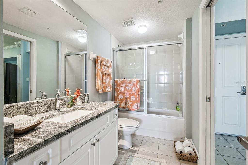 4516 Seagull Drive, Unit 807 New Port Richey, FL 34652 - Photo 34 of 100 a spacious bathroom with a granite countertop sink a toilet a mirror and shower
