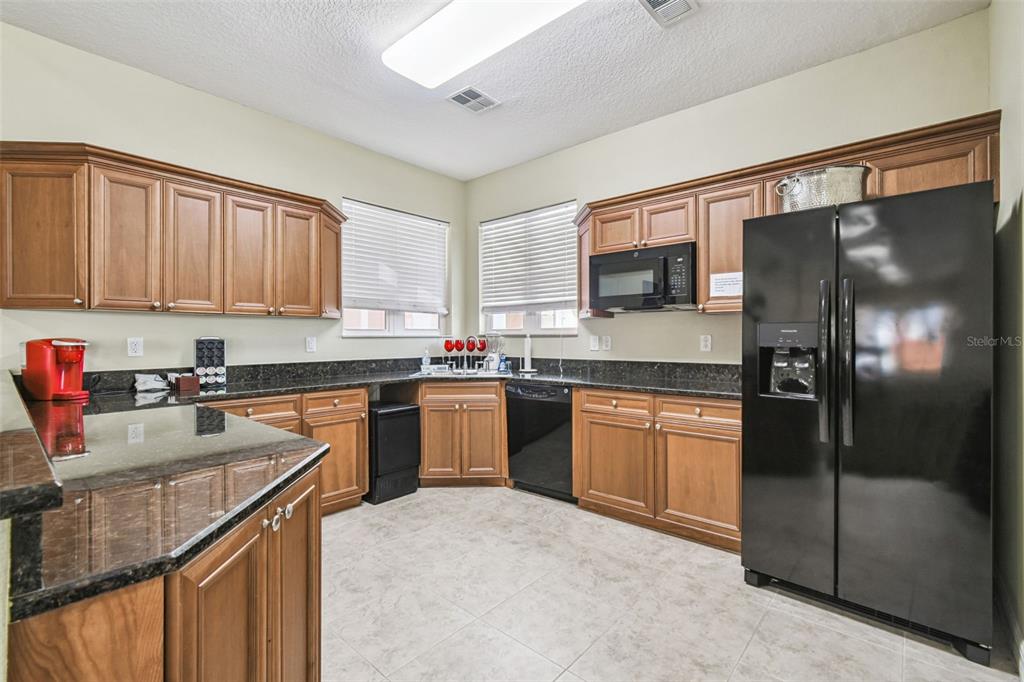 4516 Seagull Drive, Unit 807 New Port Richey, FL 34652 - Photo 56 of 100 a kitchen with granite countertop a refrigerator stove top oven a sink and dishwasher