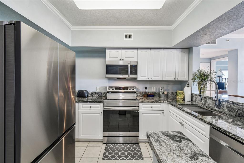 4516 Seagull Drive, Unit 807 New Port Richey, FL 34652 - Photo 7 of 100 a kitchen with a sink stove and microwave
