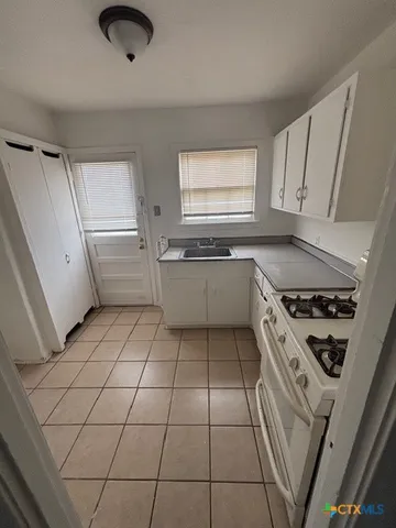 a kitchen with a sink a stove and cabinets