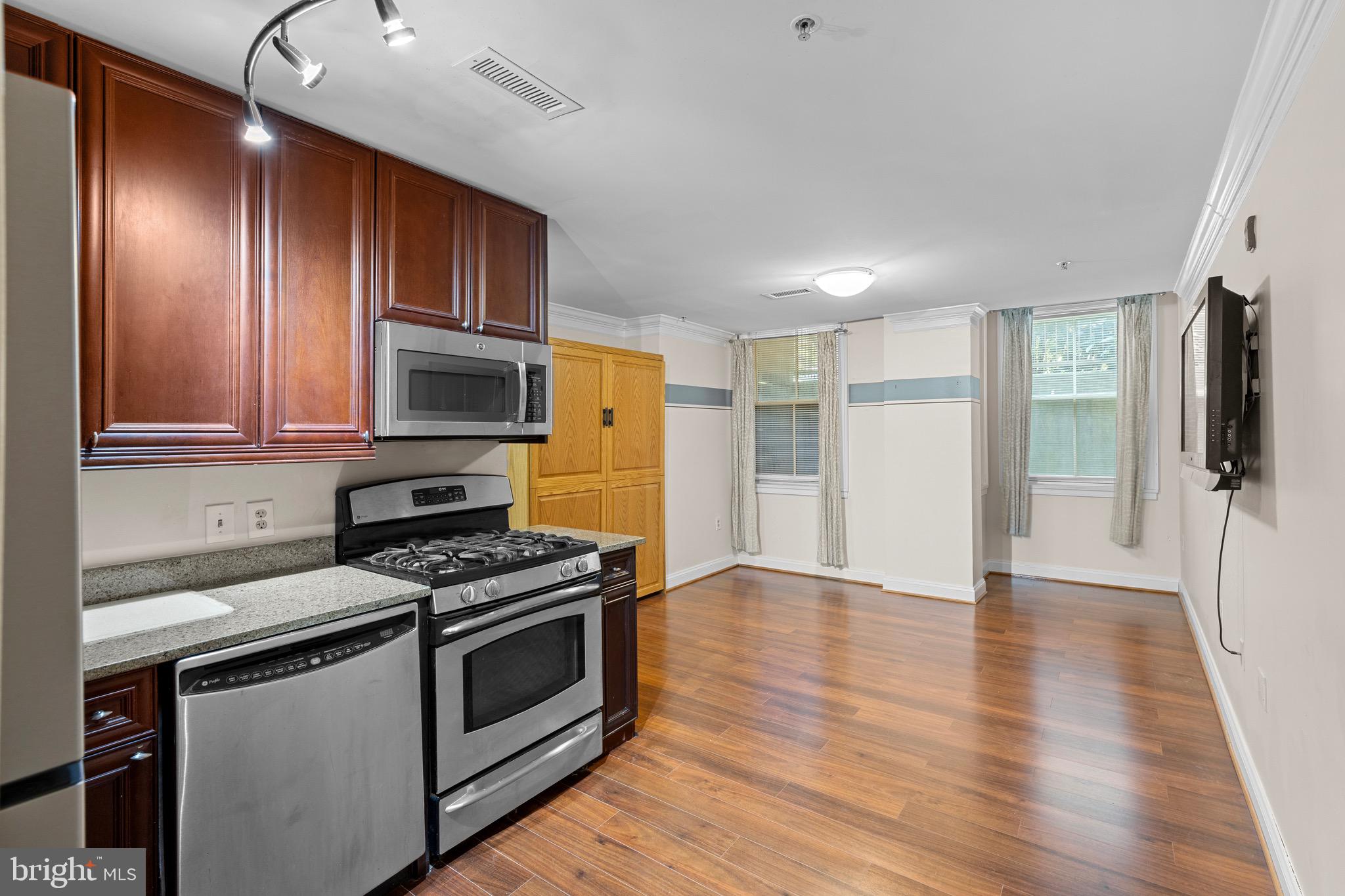 1210 R Street Northwest, Unit B1 Washington, DC 20009 - Photo 5 of 15 a kitchen with granite countertop wooden floors stainless steel appliances and cabinets