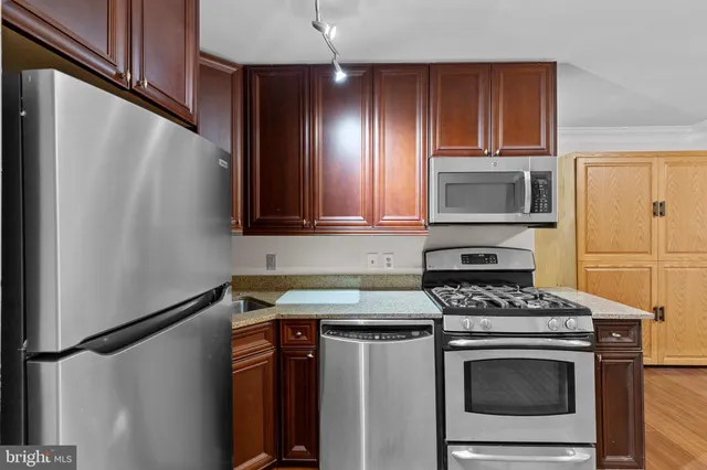 a kitchen with stainless steel appliances a stove microwave and sink