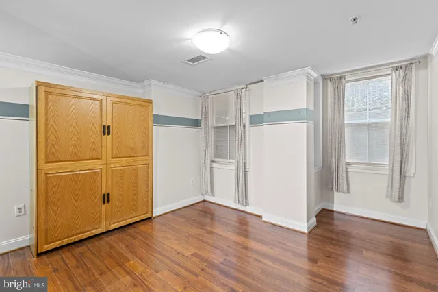 a view of empty room with wooden floor