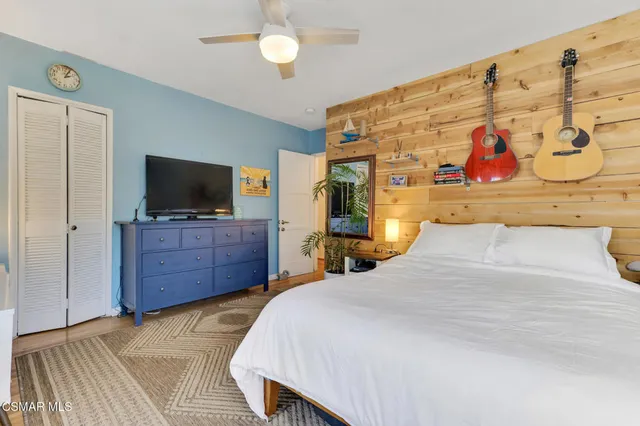 a bedroom with a bed and a painting on the wall