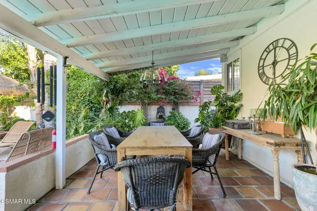 a view of a patio with couches and table and chairs under an umbrella