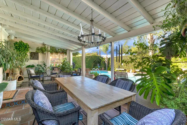 a view of a swimming pool with tables and chairs under an umbrella