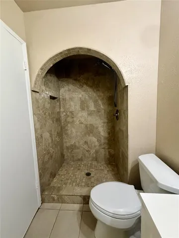 a bathroom with a toilet and a shower