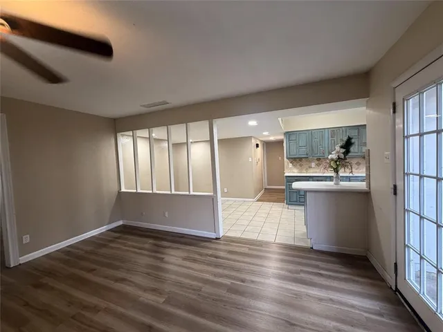 a kitchen with stainless steel appliances wooden floor and large window