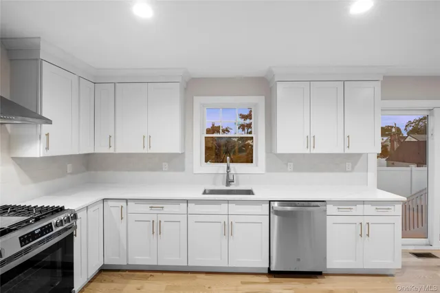 a kitchen with white cabinets and sink