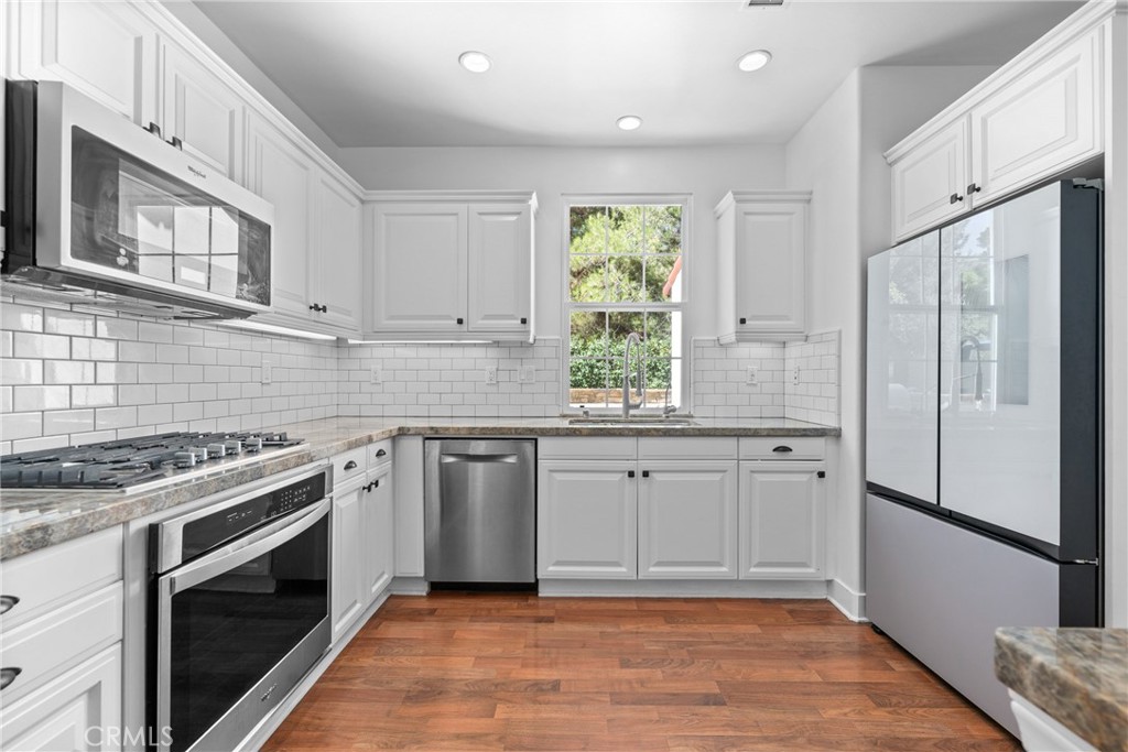 128 White Flower Irvine, CA 92603 - Photo 6 of 13 a kitchen with stainless steel appliances granite countertop a stove a refrigerator and a sink
