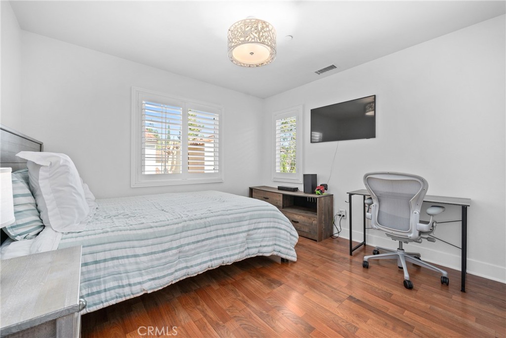 128 White Flower Irvine, CA 92603 - Photo 9 of 13 a bedroom with a bed a chair and a chandelier