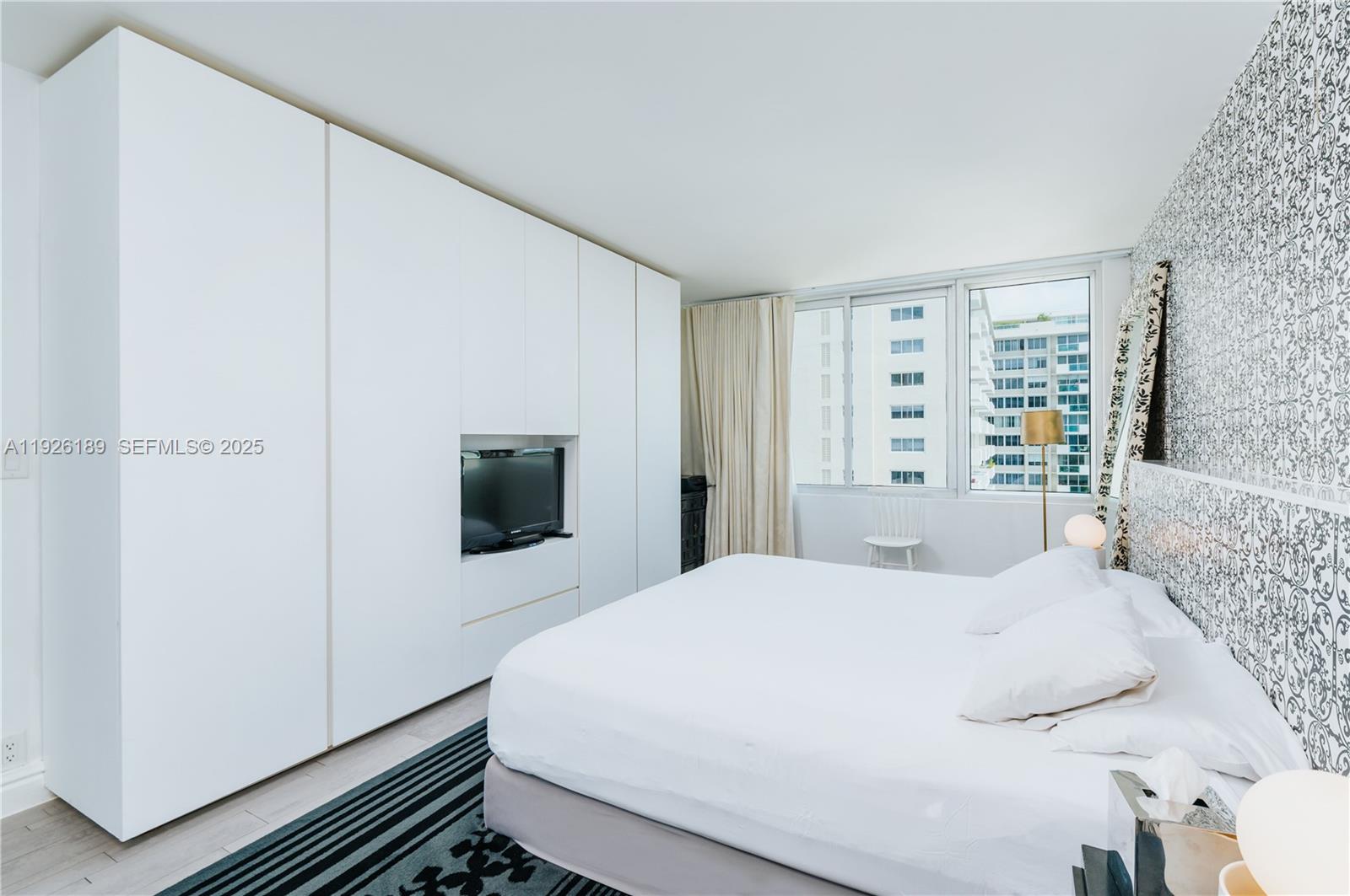 1100 West Avenue, Unit 1004 Miami Beach, FL 33139 - Photo 14 of 22 a bedroom with a bed and a flat screen tv