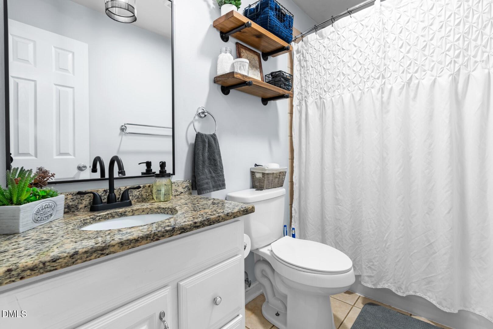 1405 Marlborough Road Raleigh, NC 27610 - Photo 18 of 33 a bathroom with a granite countertop sink and a mirror