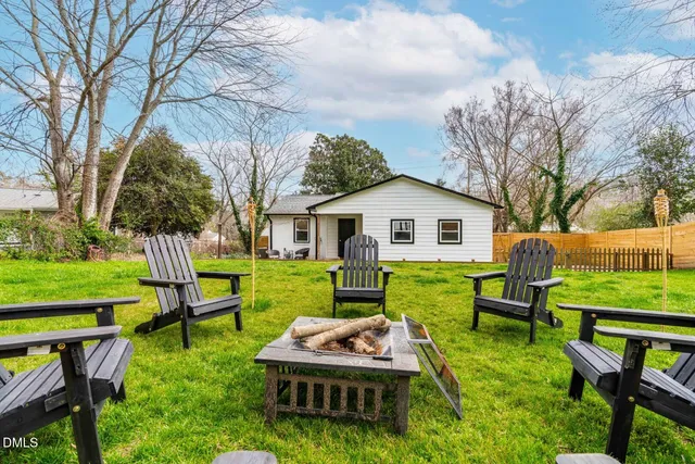 a front view of house with a garden and trees