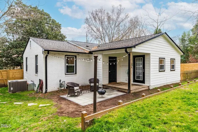 a view of a house with backyard and sitting area