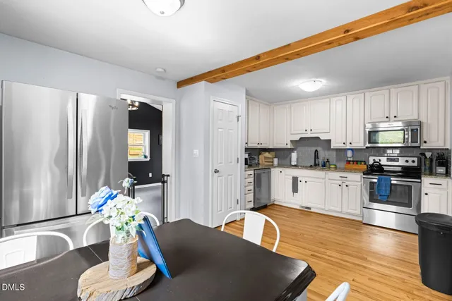 a kitchen with stainless steel appliances granite countertop a refrigerator a stove top oven and a sink